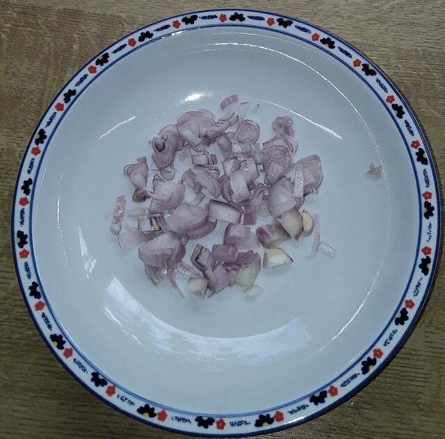 Die Schalotte (oder eine rote Zwiebel) schälen, fein hacken ...Einen hohen Topf zu 2/3 mit Wasser füllen und auf den Herd stellen, um das Wasser zum Kochen zu bringen.