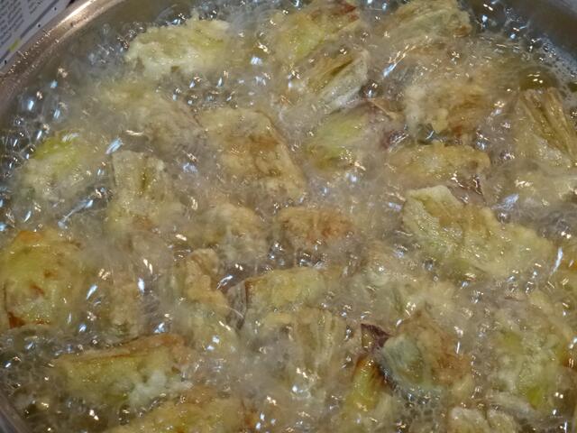 Mit einem Schaumlöffel ins heiße Öl geben, goldgelb ausbacken. Dies dauert etwa 5 Minuten. Inzwischen die Platte dick mit trockenem Küchenpapier auslegen.