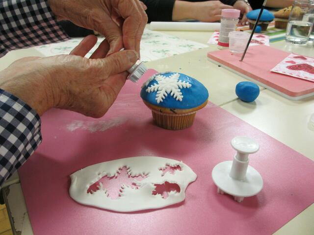 Kunstvoll werden die kleinen Dekore hergestellt, die Muffins eingedeckt und ausdekoriert.