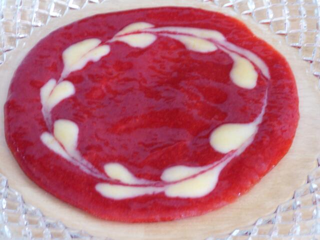 Mit einem Holzstäbchen oder Teelöffelstiel eine Linie durch die Tupfen ziehen - so entsteht das Herzmuster.