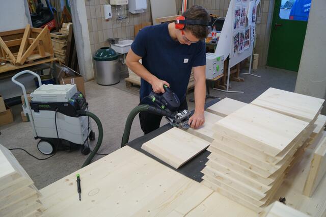 Unzählige Holzelemente werden von den Auszubildenden für die Wabenwand vorbereitet.