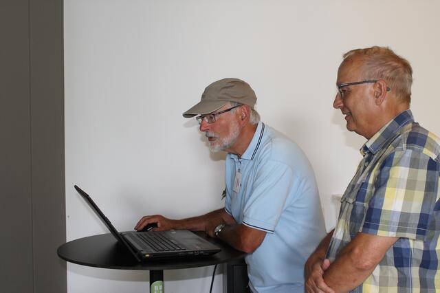 Gerhard Hölzel zieht die ausgewählten Bilder von Gerd Bohnenberger und den anderen Teilnehmern auf den PC.  Zusammen schauten sich alle die Werke des Tages in der Buga-Lounge an. | Foto: Katja Bernecker