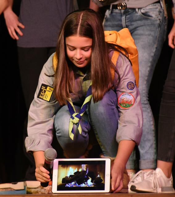 Eine Pfadfinderin der Sippe Panda zündet das Lagerfeuer der Zukunft auf dem Mars an.