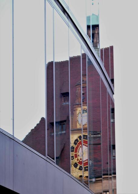 Rathausuhr im Fenster des Stimme-Glashauses