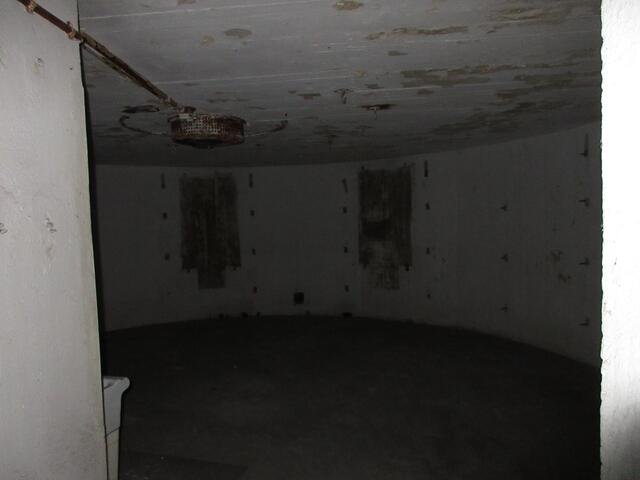 42 Mann in einem fensterlosen Raum, die Haken an der Wand sind für Pritschen.