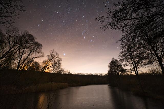 Sternenhimmel mit Sternbild Orion überm Seeloch