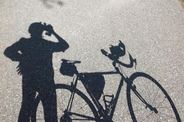 Der Schattenmann bei seinen Hobbys Fotografieren und Fahradfahren.