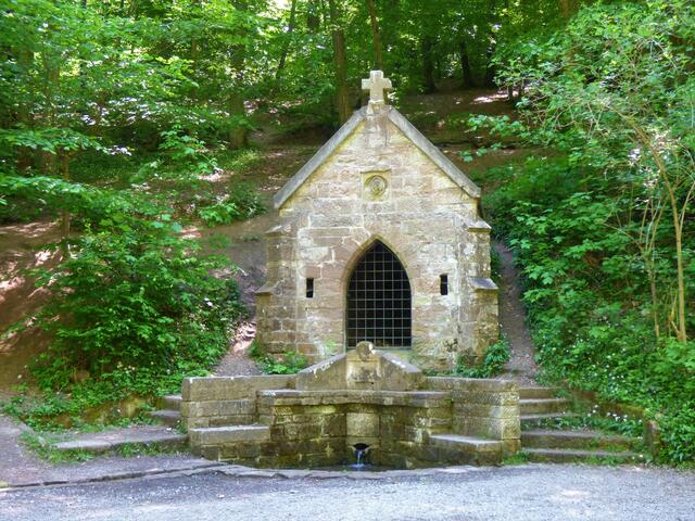 Die historische Kapelle mit der eingefassten Köpferquelle .