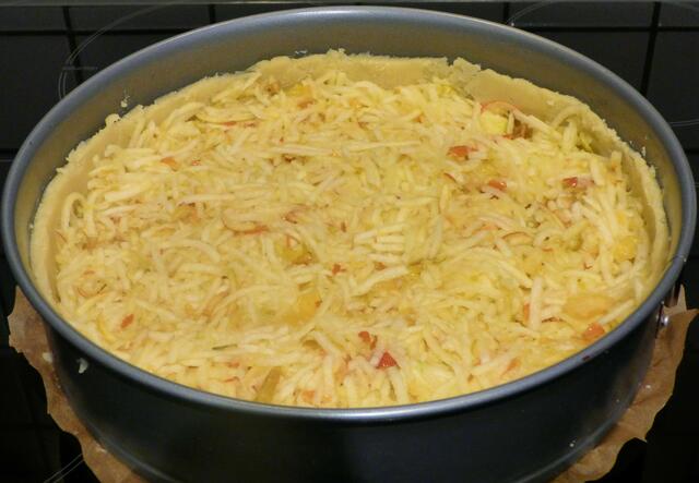 Die geraspelten Äpfel gleichmäßig als Füllung auf dem Teig verteilen und etwas andrücken.
