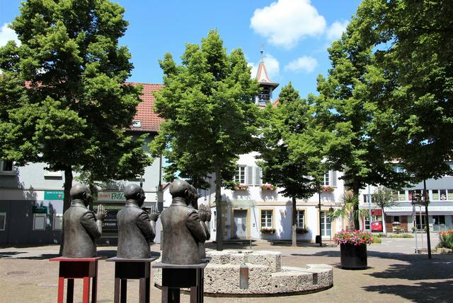 Fleiner Rathausplatz mit Skulptur, im Hintergrund das alte Rathaus
