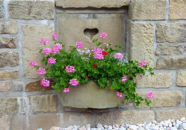 Blumige Dekoration an der Mauer des ehemaligen Wirtschaftsgebäudes