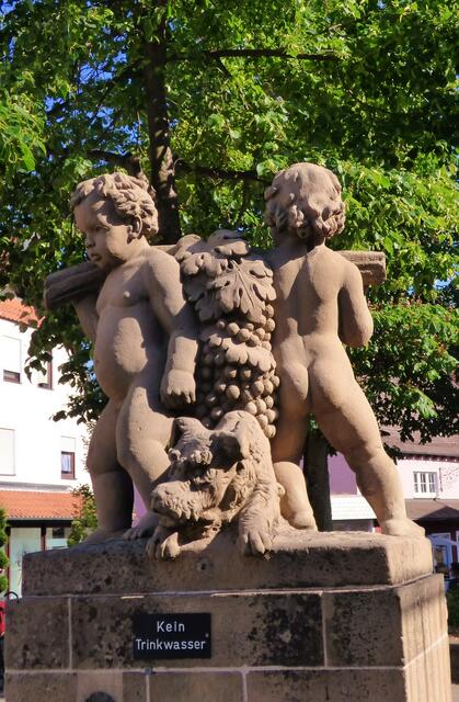 Welches Städtchen lässt zwei Nackedeis die süßen Trauben tragen? Und wie heißt der Brunnen? --- 7. Buchstabe des Brunnennamens.....