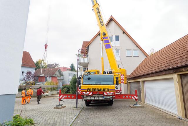 Da der Platz zwischen Autokran und dem Haus links für die Brücke etwas knapp war, wurden beide Brückenteile kurzerhand über das dreistöckige Haus gehoben. 