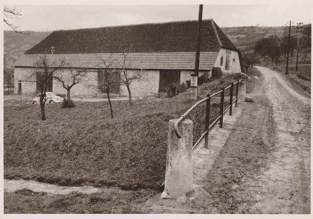 Die historische Kelter von 17_ _  auf einem Foto von um 1960?, vorne Brücke über den Heiligenbach - das Objekt der Diskussionen um die künftige Nutzung als Sport-und Veranstaltungshalle oder als Reit-/Reittherapiehalle