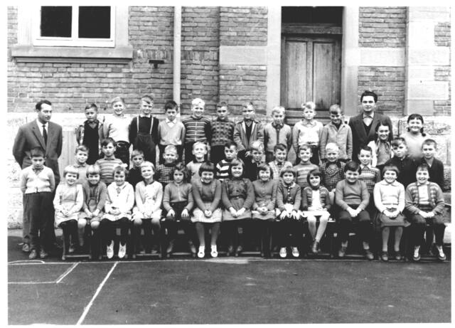39 Schüler der 'Unterklasse' mit Rektor Willi Braun und Klassenlehrer Eugen Ziegler. Aufgenommen auf dem Pausenhof, vor der Rückseite des Schulhauses im Schuljahr 1961/62; Quelle: Reinhold Leja, Kocherstetten