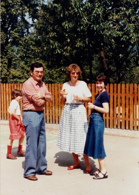 Rektor Eugen Ziegler mit den Lehrerinnen Gisela Kütterer und Angelika Di Girolamo auf dem Pausenhof. Die Mauer war wegen schlechtem Zustand durch einen Holzzaun auf stabilem Sockel ersetzt worden. Aufnahme von 1984, privat