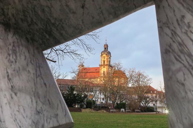 Blick durch Marmorskulptur auf die katholische Kirche in Neckarsulm