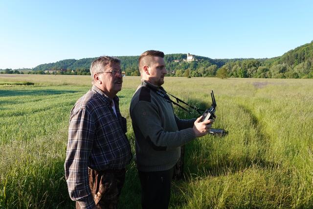 Mit leisem Gebrumm fliegt die Drohne ihre Suchschleifen über der Neckarwiese gegenüber Burg Guttenberg.