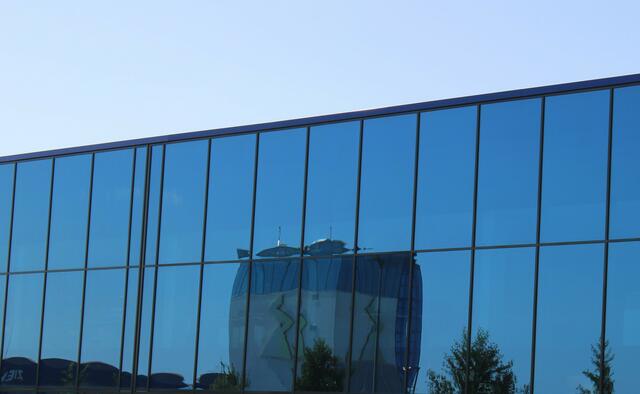 Der Turm der Firma Ziehl-Abegg spiegelt sich in den blauen Fenstern des Firmengebäudes