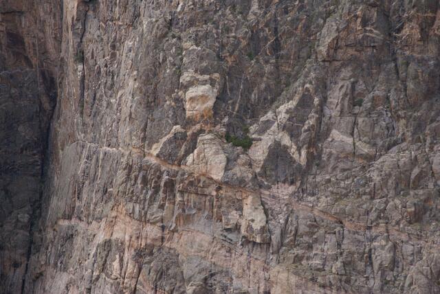 sitzender Mann mit zugekniffenen Lippen und Bocksfuß
