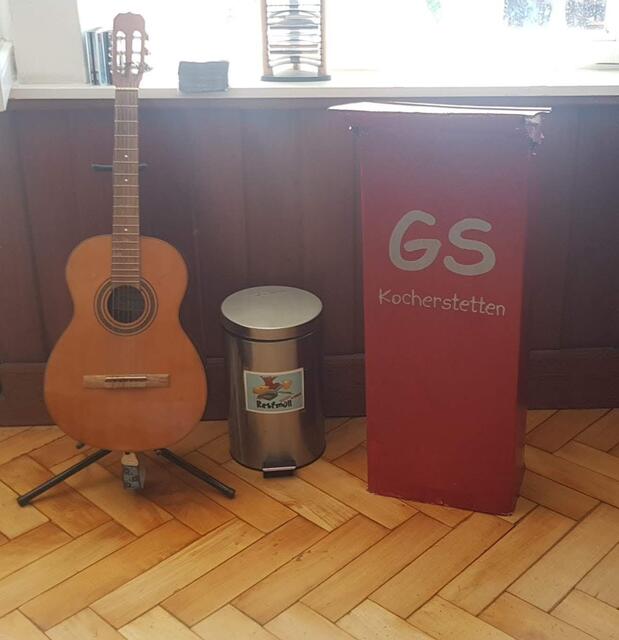 Drei "Mitspieler" beim Programm: Gitarre, Mülleimer (symbolisch für die Mülltonnen, in die zwei kaugummikauende Schüler nicht, die vom Lehrer gemeinten Kaugummis, sondern sich selbst hineinbeförderten) und schon 2012 gebasteltes Rednerpult, das beim "Schultheater" als Lehrerpult eingesetzt wurde
