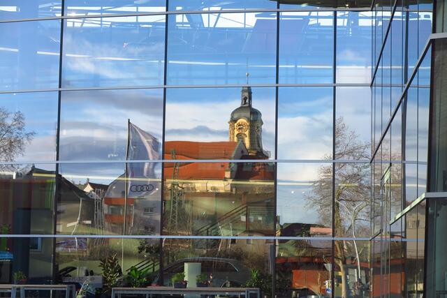 Kirche in Neckarsulm spiegelt sich in der Glasfront des AUDI-Forums