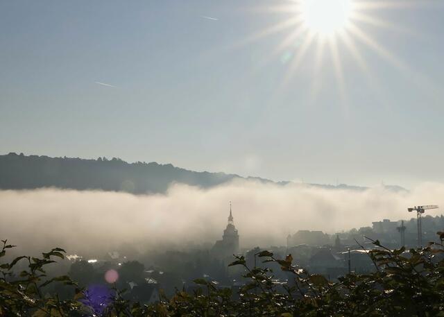 Die Sonne löst den Morgennebel über dem Kocher in Künzelsau auf