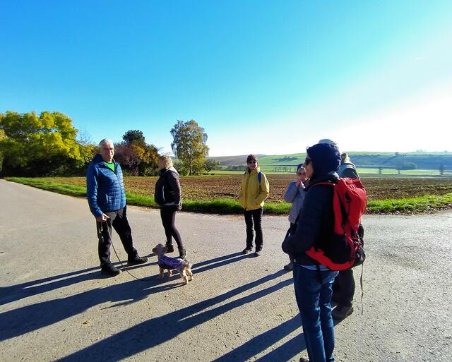 Die Wanderer werfen in der Vormittagssonne lange Schatten. Und unser Wanderguide Alex wartet auf den Rest der Truppe