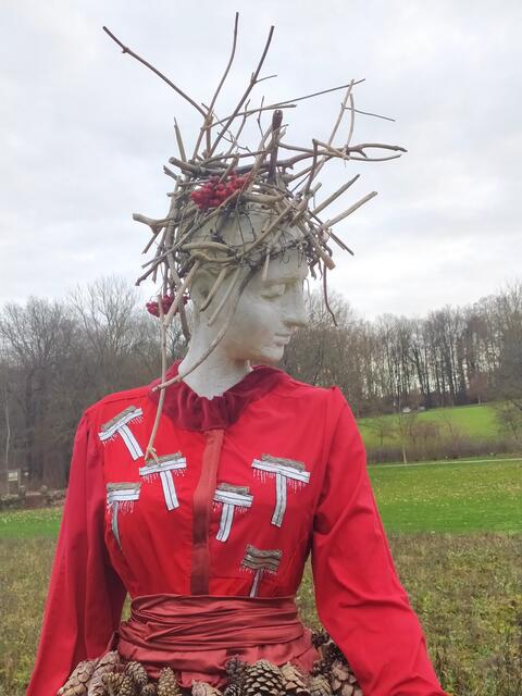 Mit den roten Beeren steht auch ihr Kopfschmuck für Wildvegetation