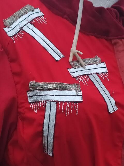Stilisierte Bäume schmücken die rote Jacke