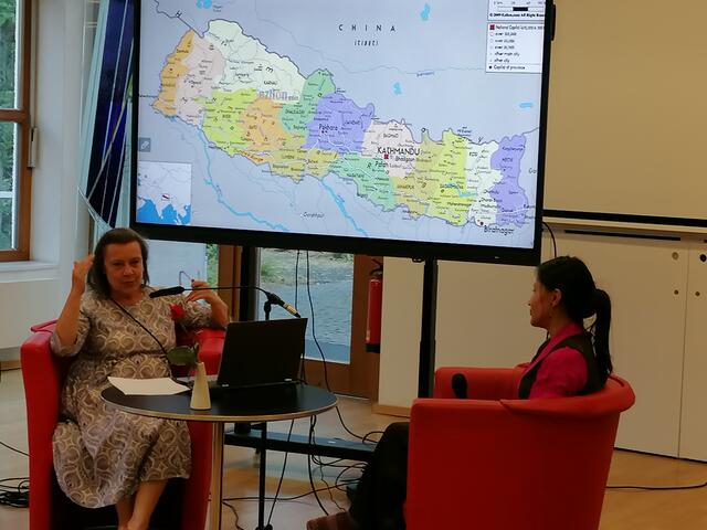 Angelika Hart (links) und Yang Sung Sherpa beim Interview vor einer Karte von Nepal.
