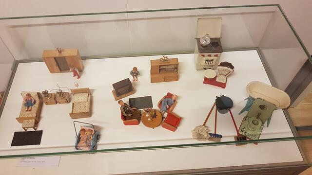 Eine Wohnung im Stil der 1950er Jahre. Bei den Puppen ist mir zuerst die Mutter aufgefallen, die auf dem Sessel mehr liegt als sitzt. Warum wohl? ... Der Vater hingegen sitzt kerzengerade und lauscht vermutlich den Nachrichten aus dem Radiogerät.   | Foto: eigene Aufnahme 