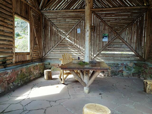 Im Inneren kann man herrlich ausruhen und entspannen - neben dem Tisch steht ein Lesesessel und Bücher gibt's in einem Bücherschrank