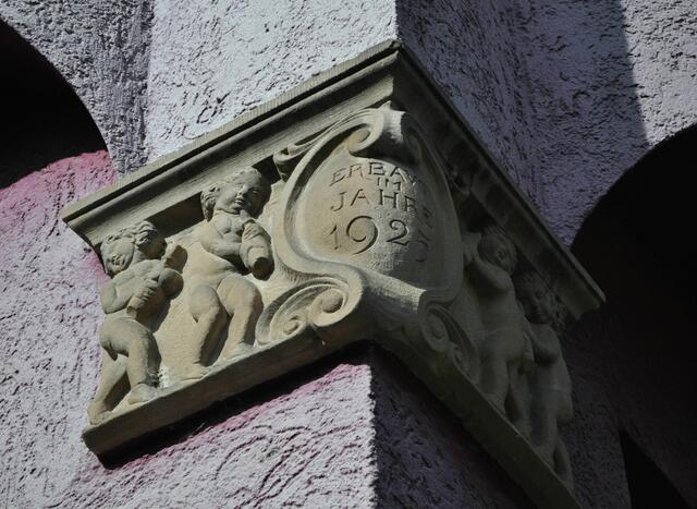 Konsolsteine an den Ecken mit dem Erbauungsjahr und Kinder die Milchflaschen tragen. | Foto: Daniela Somers