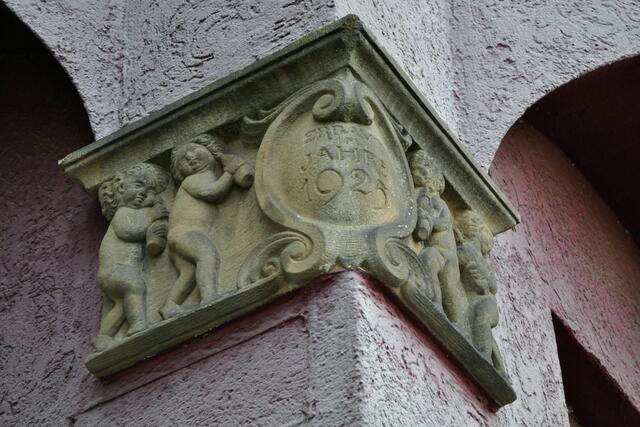 Konsolsteine an den Ecken mit dem Erbauungsjahr und Kinder die Milchflaschen tragen. | Foto: Daniela Somers