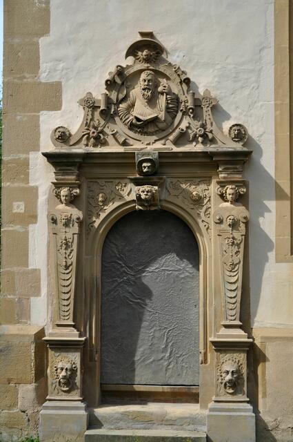 Nebenportal der Kapelle mit dem Medaillon des hl. Jacobus. Er hat Pilgerflasche und Pilgermuschel bei sich. | Foto: Daniela Somers
