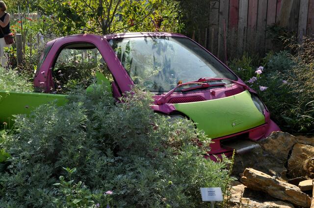 Experimentierfeld. In diesem Garten wurde ein Auto im Garten intergriert. Aus der Mitte wächst ein Baum und der Anfang eines Bachlaufs wurde auch darin verbaut. | Foto: Daniela Somers
