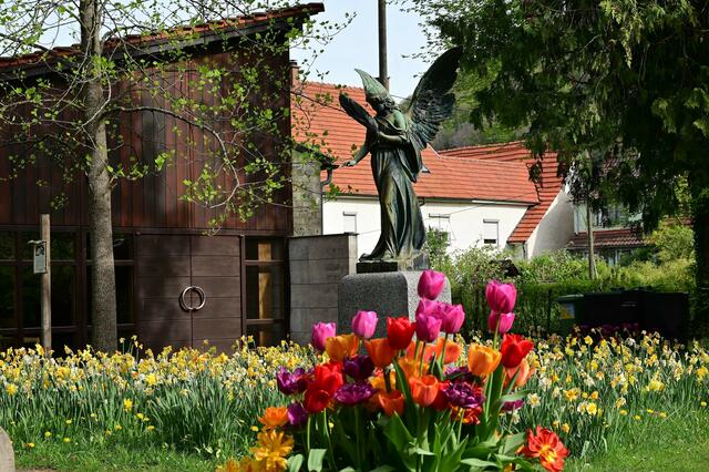 Eine schöne Statue auf dem Friedhof, mit farbenprächtigen Tulpen toll in Szene gesetzt.  | Foto: Michael Harmsen