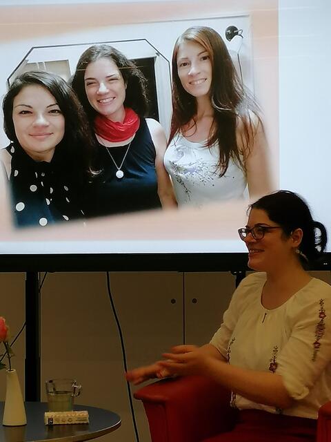 Die Erzählerin vor einem Bild zusammen mit ihren Schwestern. | Foto: privat