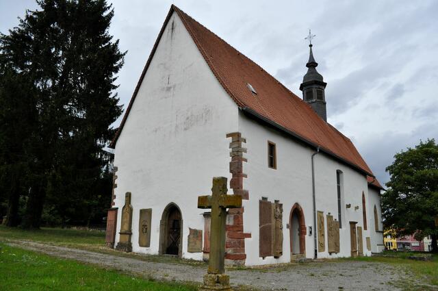 Früher war der Friedhof rund um die Kirche. An der Außenwand der Kirche kann man heute viele Grabplatten der Herren von Helmstatt anschauen. | Foto: Daniela Somers
