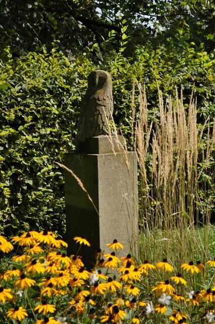 Diese schöne Eule aus Sandstein steht in einem schönen Blumenbeet | Foto: Daniela Somers
