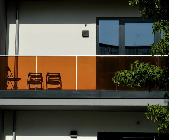 Auch eine schlichte Fassade kann interessant aussehen: Durch das orangefarbene Geländer wirkt sie hier wie moderne Kunst. | Foto: Elektra Domesle