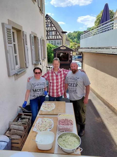 Ortsvorsteher Klaus Eckert inmitten von den "legendären Bäckern" Conny und Tim Metz. Dahinter der Holzbackofen. | Foto: Hans J. Leuz