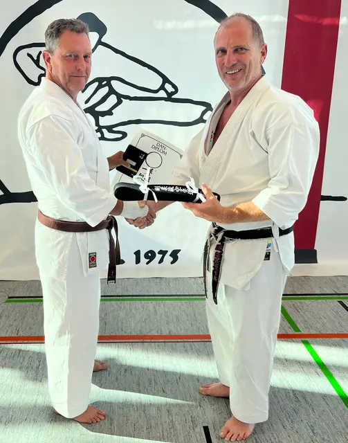 Dojoleiter Matthias Schäfer (rechts) gratuliert dem neuen DAN-Träger Oliver Spörle zur bestandenen Prüfung und überreicht ihm den schwarzen Gürtel | Foto: Karateverein Eppingen