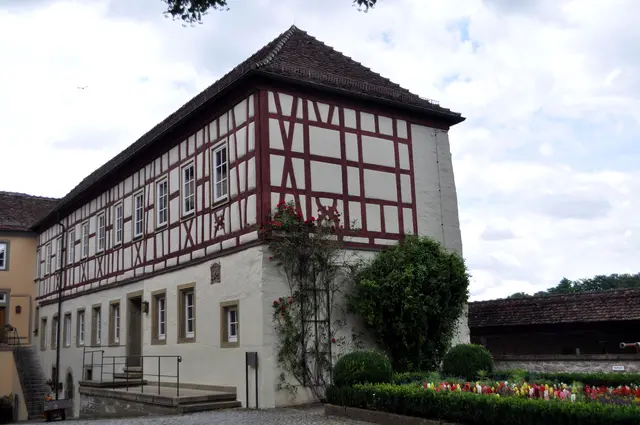 Wamboldbau. Inschriftlich datiert auf 1563. Das Gebäude erinnert mit seinem Namen an den Stiftsherrn Carl Ludwig Freiherr von Wambold (1769-1842). Er gehörte dem Ritterstift an und war auch Domherr in Würzburg und Bamberg. | Foto: Daniela Somers