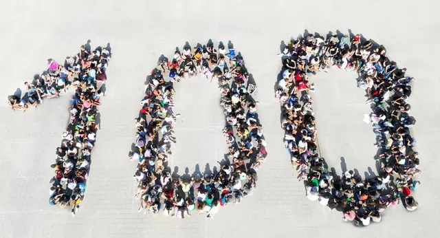 Die Schulfamilie der JHS als "100" auf dem Schulhof.  | Foto: JHS