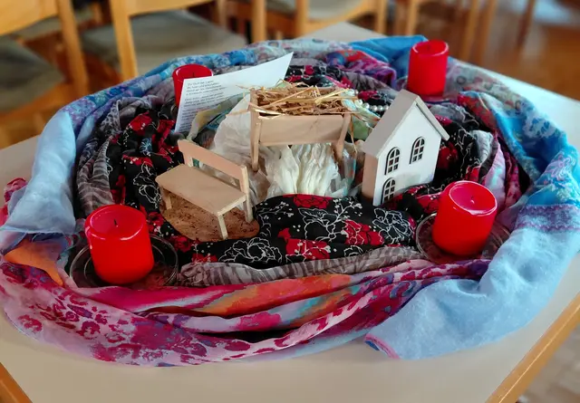Die vier Kerzen mit kleinen Häusern, Mini-Holzbank, Bild von Greccio und Perlenkette. | Foto: Hans J. Leuz