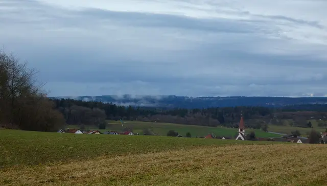 Häuser und Kirche von Simmozheim spitzen aus dem Tal hervor und hinten steigt noch der Nebel auf.  | Foto: sigischlottke