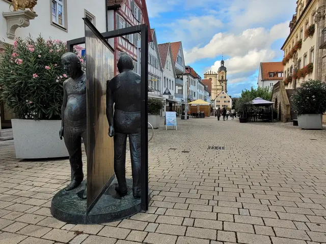 Die Drehtüre in Neckarsulm. Menschen gehen aneinander vorbei. | Foto: Hans Peter Schmitt
