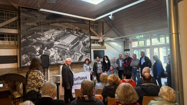 Erich Schuch vom Heimat- und Museumsverein Bad Rappenau hielt die Eröffnungsrede. Die elf anwesenden Heimatreporter stehen daneben.  | Foto: Vivien Müller